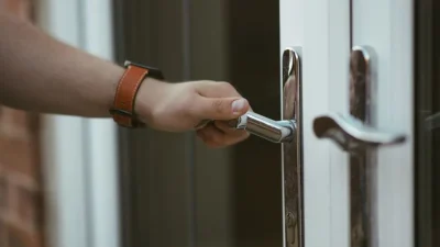 ahl closeup shot person holding door knob opening door