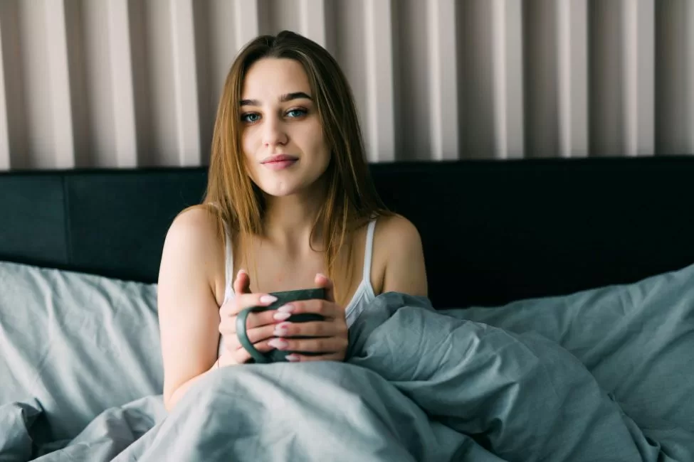 ahl portrait young woman drinking coffee bed home